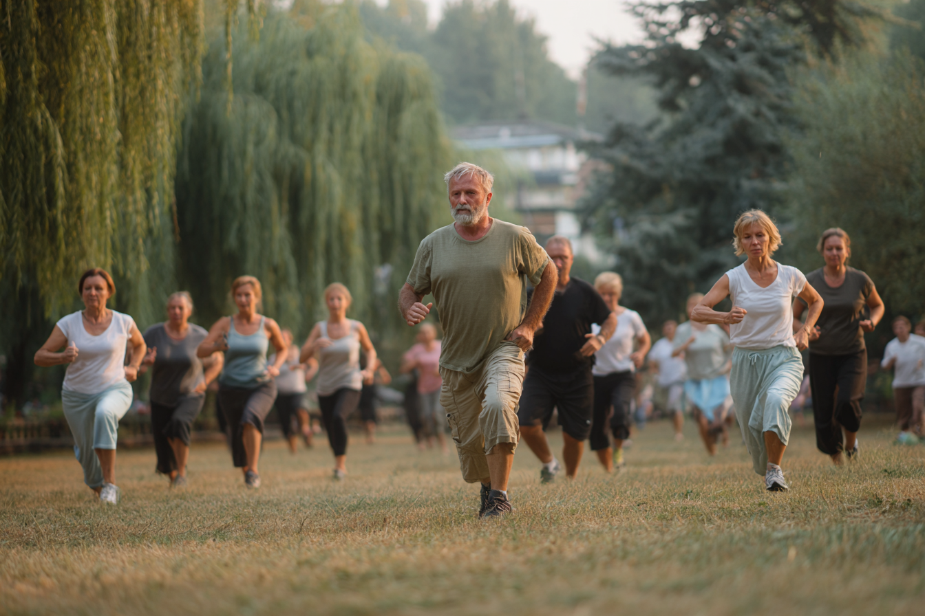 Тренер працює з групою старших людей на свіжому повітрі